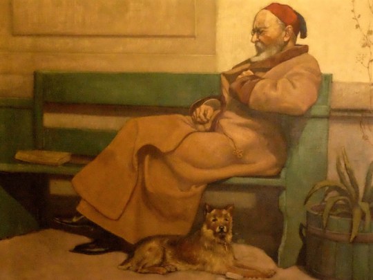Die Abbildung zeigt J. V. Widmann auf einer Bank sitzend. Zu seinen Füssen liegt ein Hund, welcher direkt die Betrachter:in anzuschauen scheint.