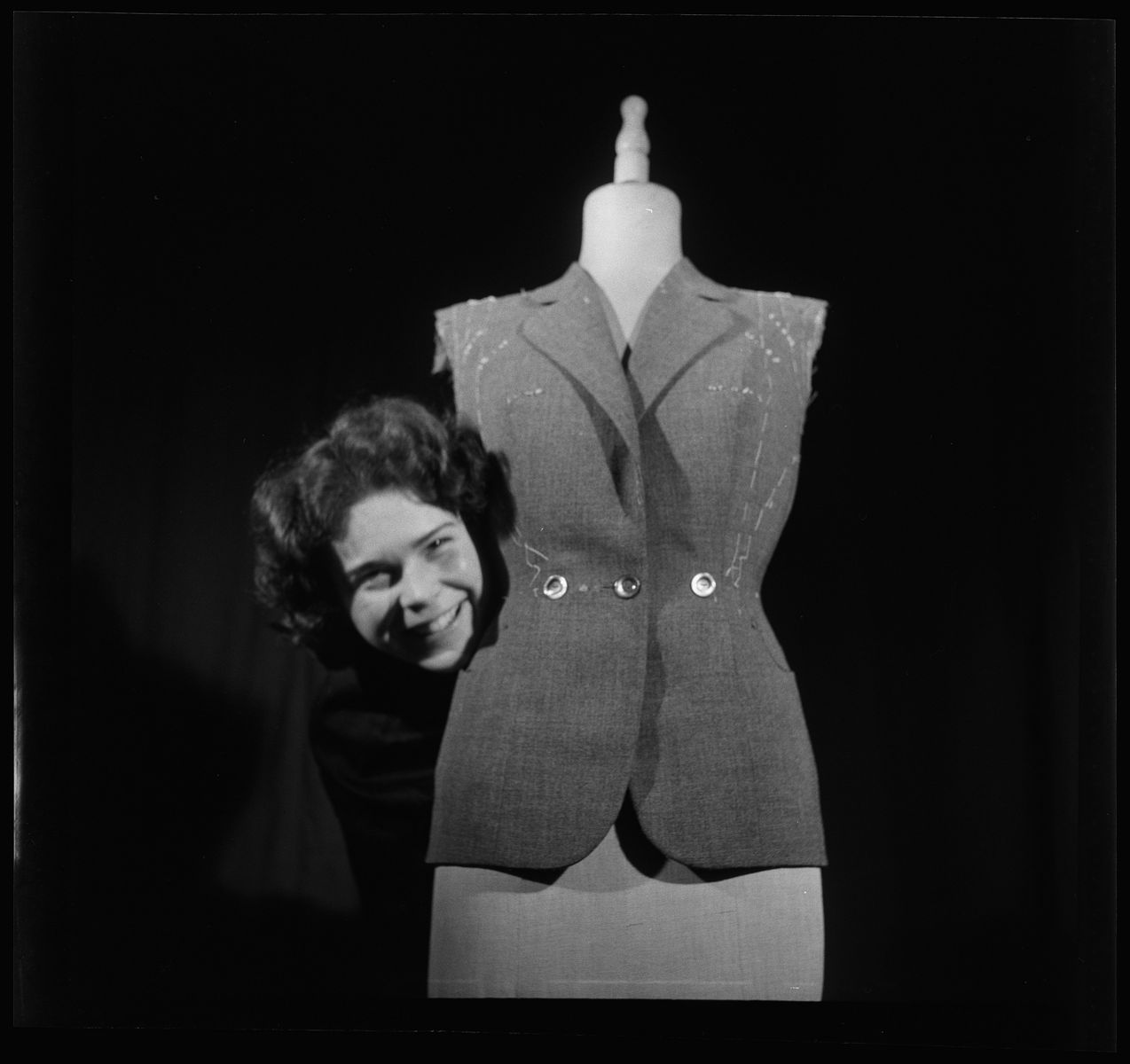 Frau welche hinter eines Mannequin hervorschaut.