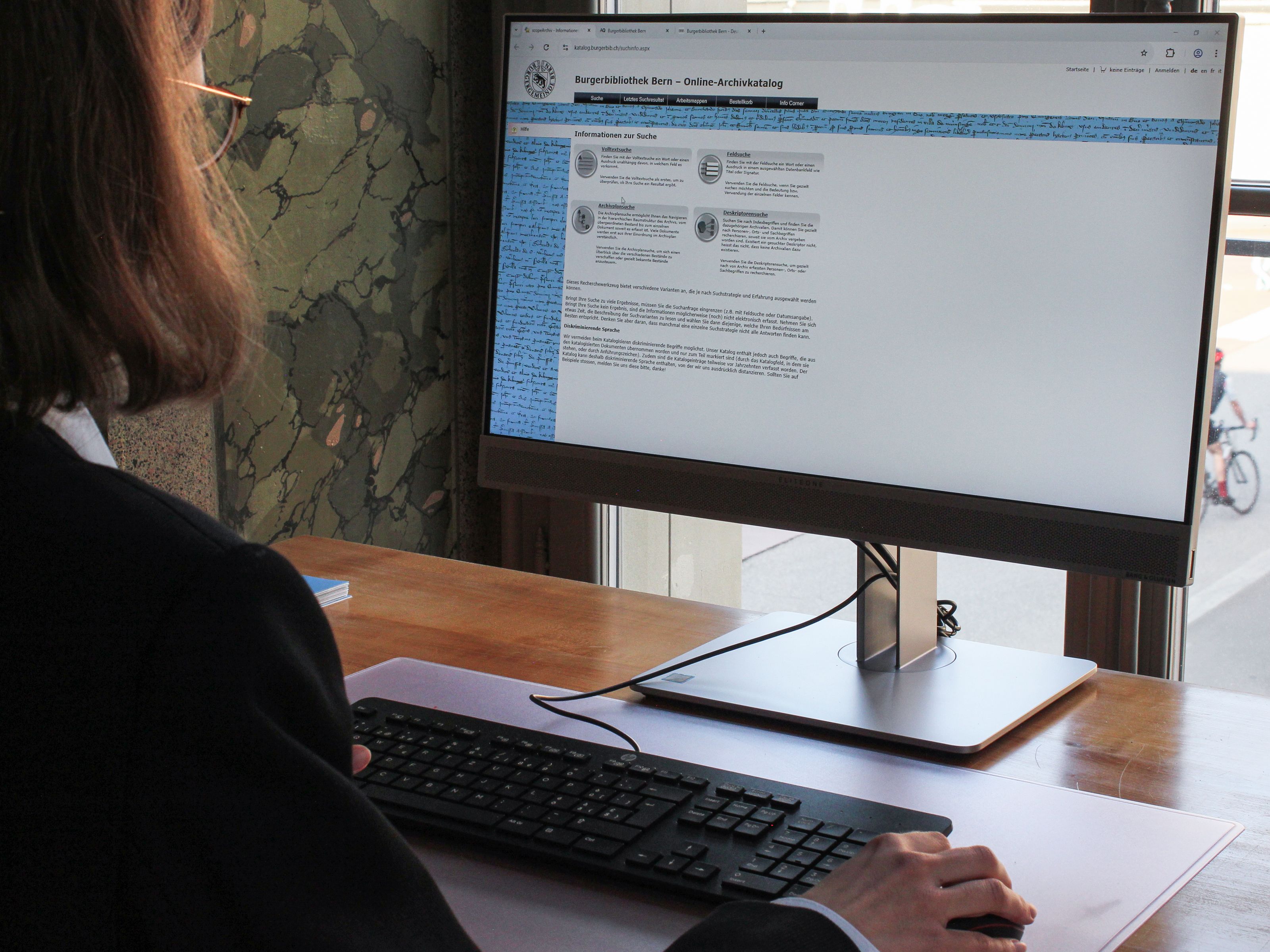 Eine Person recherchiert am PC im Lesesaal.